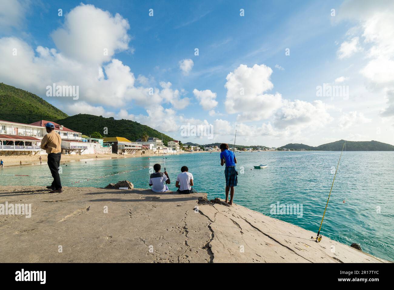 Young fishermen on a pier at Grand Case in Saint Marteen Stock Photo