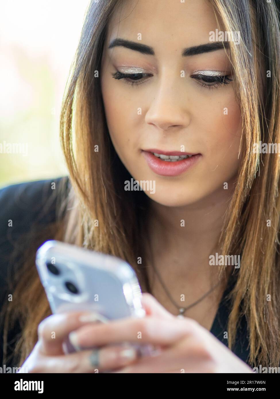 asian female model using smartphone outdoors Stock Photo