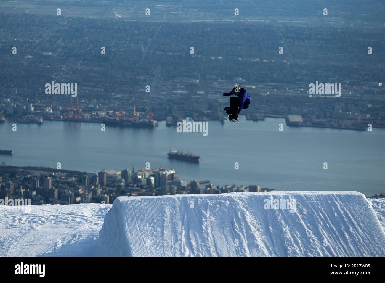 Snowboarder Hits Jump Overlooking View of Vancouver Canada Stock Photo