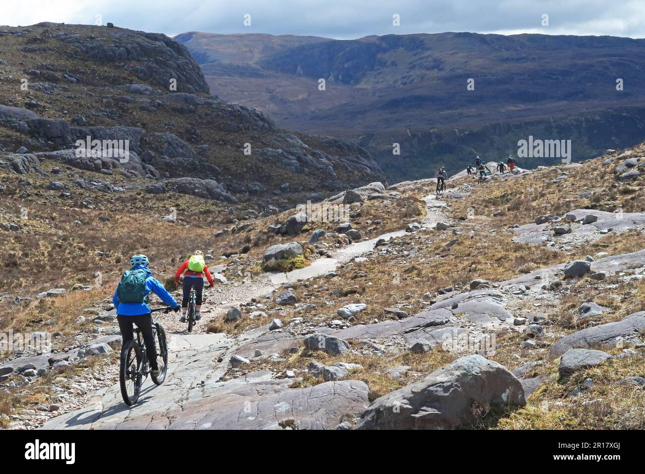 Scottich Highlands, Coulin Estate. Mountain bikers descend Coire Lair towards Loch Dughaill, near Lochcarron. Peaks of Sgurr na Feartaig beyond. Stock Photo