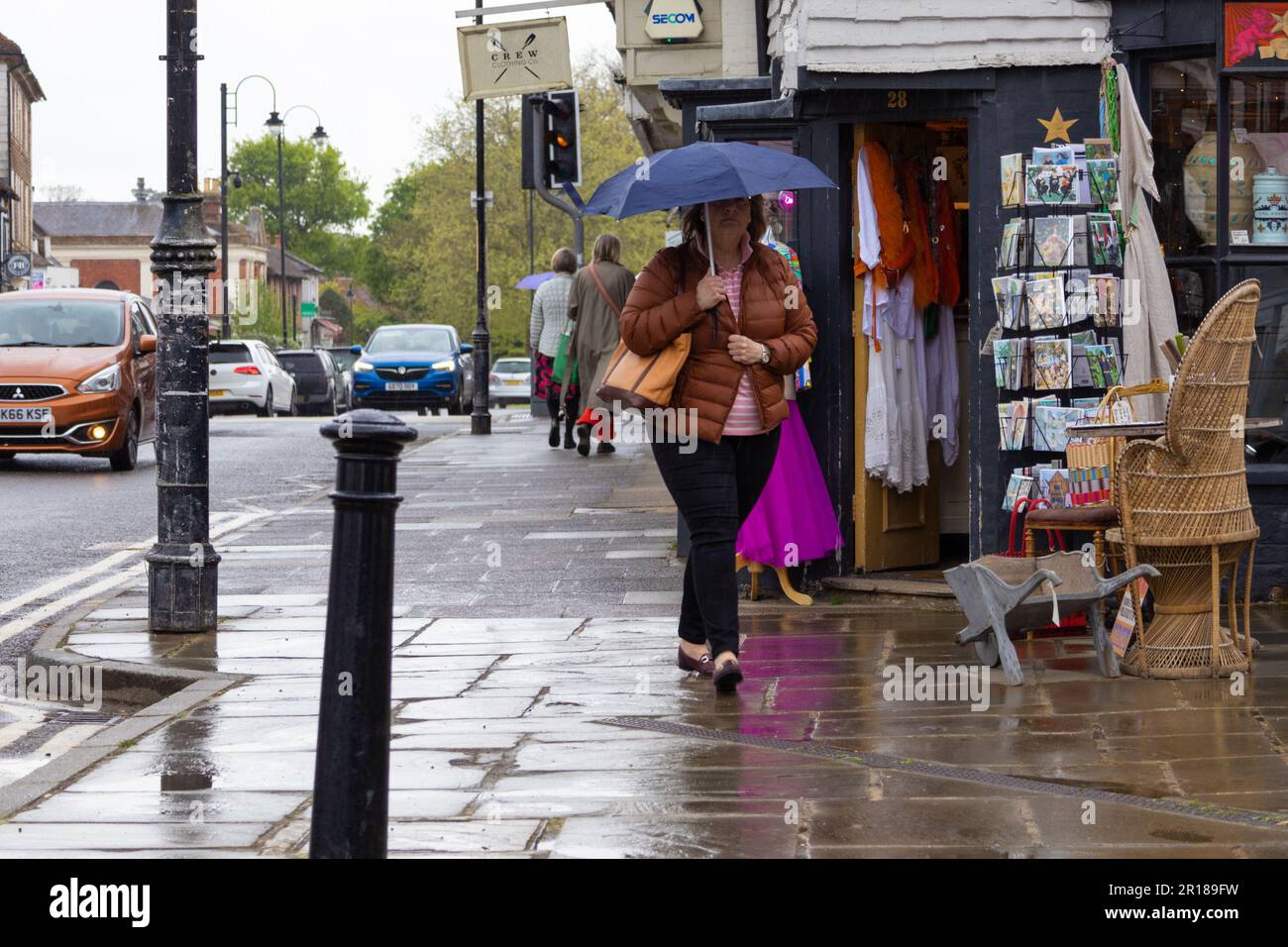 Tenterden, Kent, UK. 12th May, 2023. UK Weather: People shelter from the rain most with umbrellas in Tenterden town high street, Kent, UK. Photographer: Paul Lawrenson, Photo Credit: PAL News/Alamy Live News Stock Photo