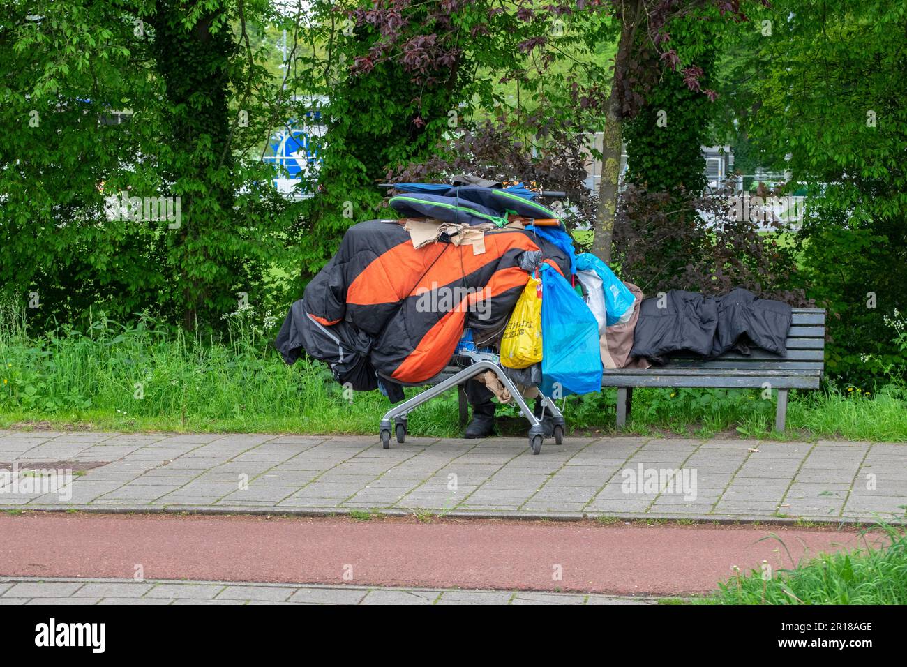 Homeless Man Sitting On A Bench With Shopping Cart At Amsterdam The Netherlands 1052023 Stock