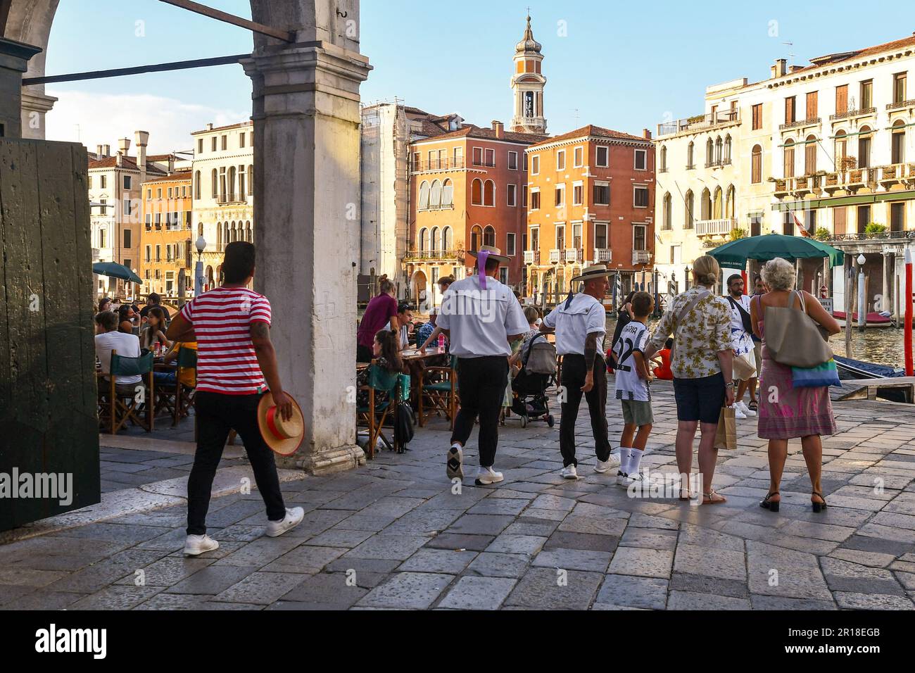 Gondoliers arrive to work in Campo dell'Erbaria, square overlooking the Grand Canal during the crowded evening happy hour, Venice, Veneto, Italy Stock Photo
