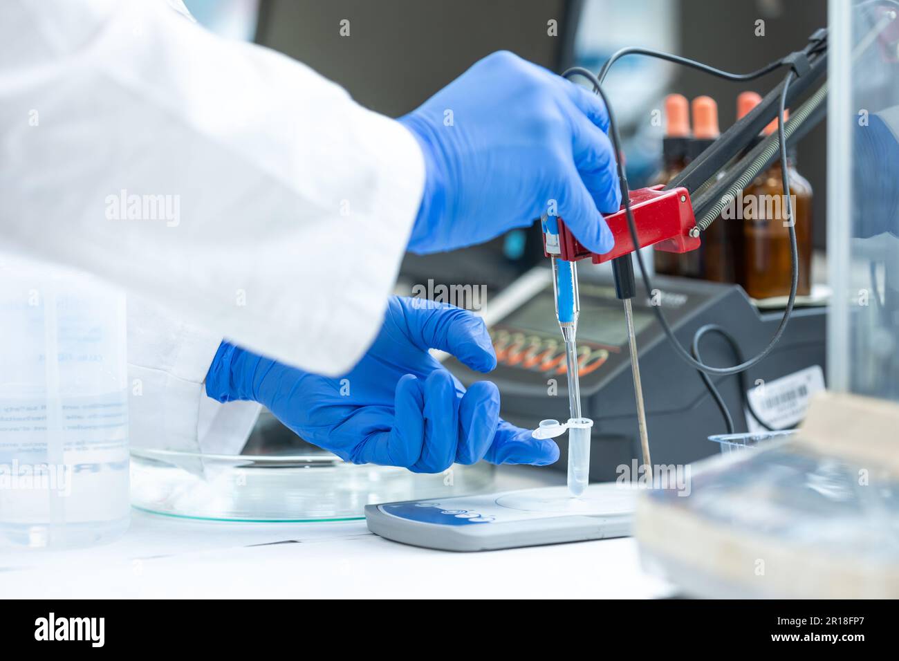 Laboratory technician holding glass electrode for measuring of pH of the solution using a pH meter., analytical or electro chemistry laboratory, lab Stock Photo