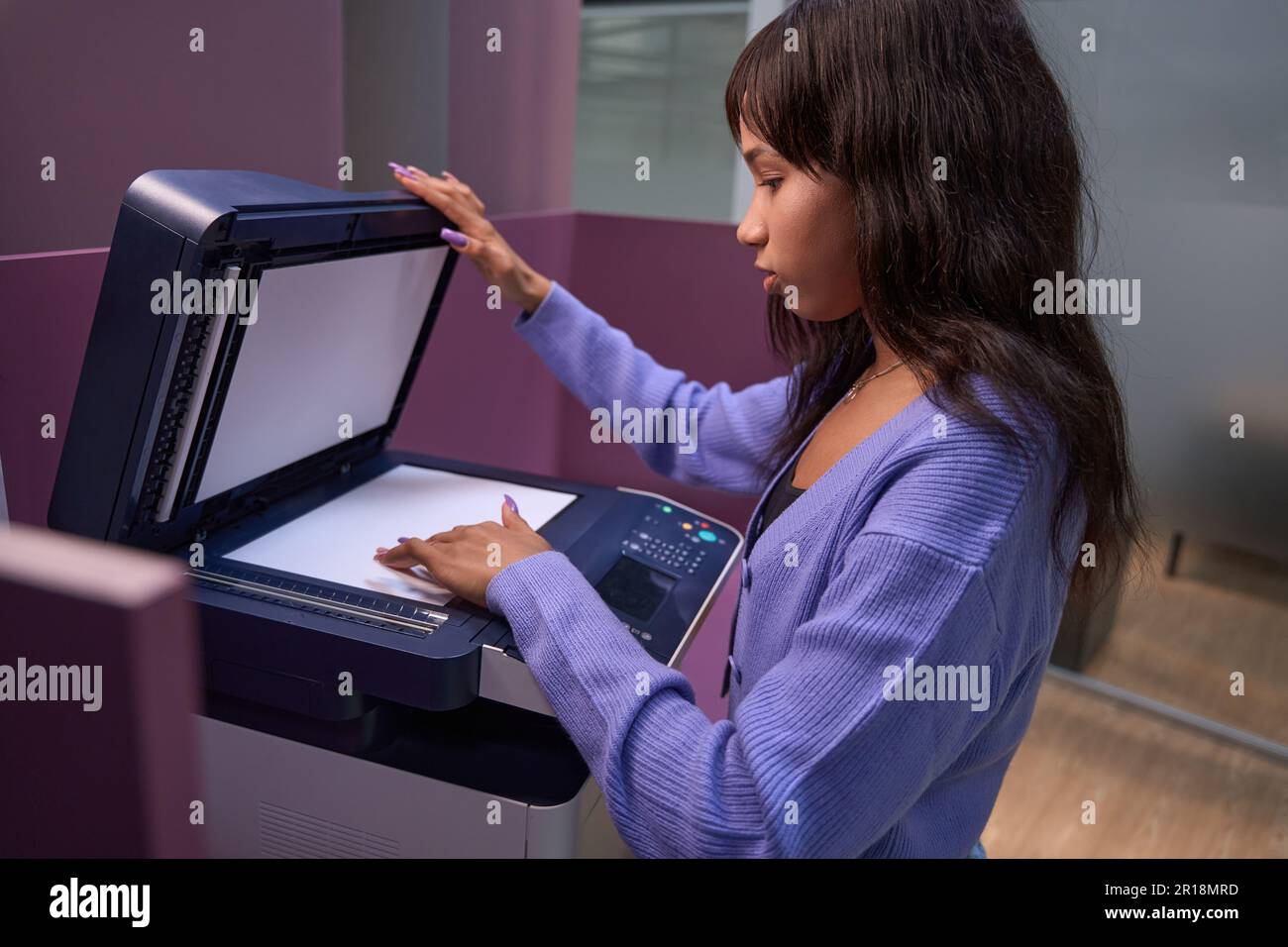 Serious woman worker using multifunction printer in office Stock Photo