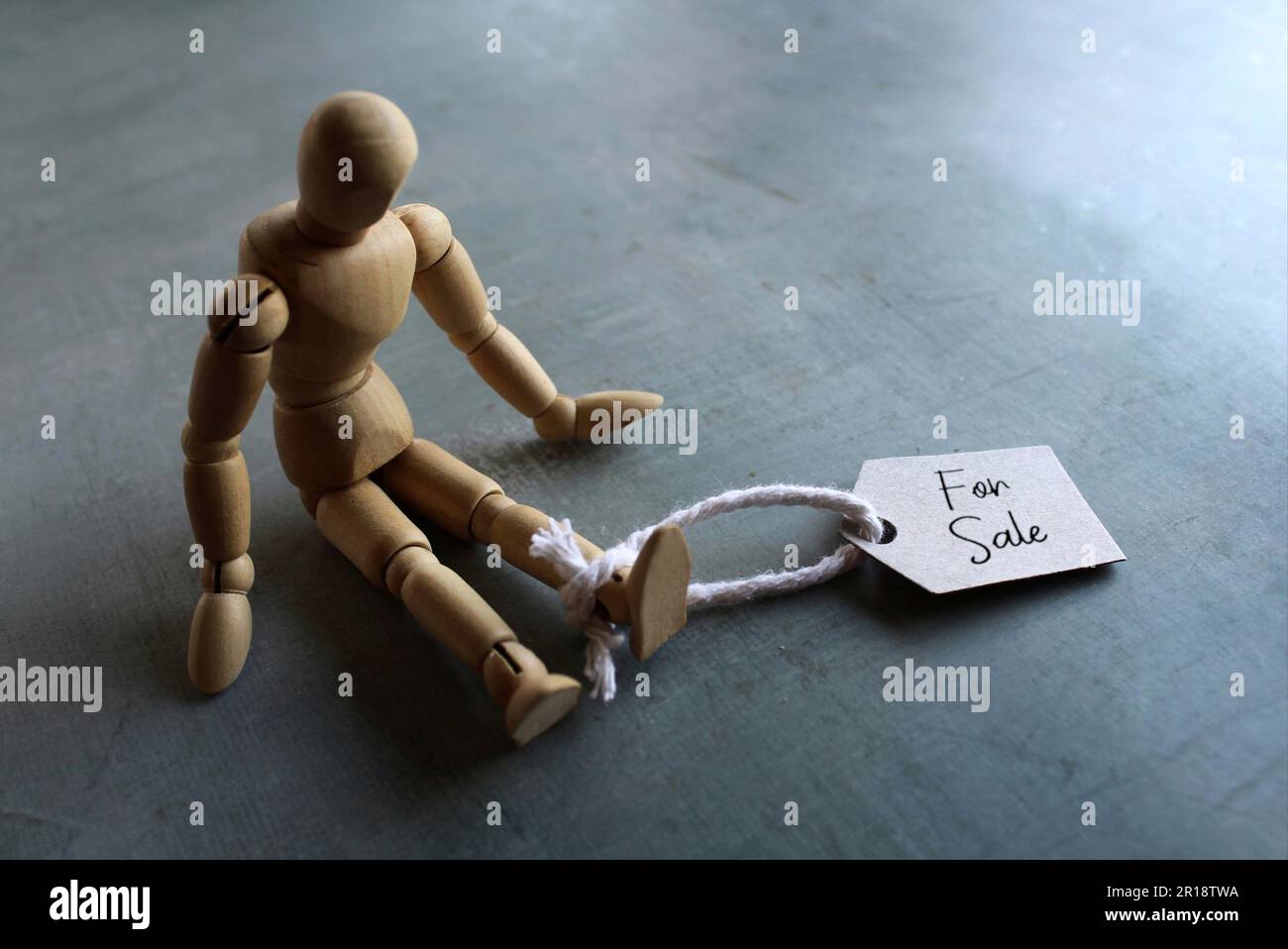 Selective focus image of doll with tag FOR SALE. Human trafficking concept Stock Photo