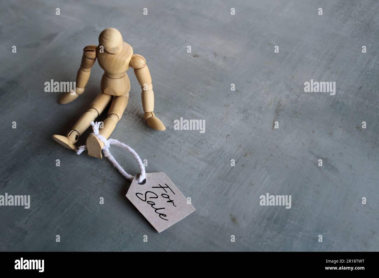 Selective focus image of doll with tag FOR SALE. Human trafficking concept Stock Photo
