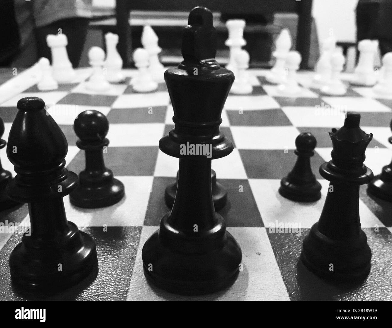 Close-up shot of a chess set. Concept of challenge, competition, strategy, victory, business, team management and leadership. B&W Landscape Stock Photo