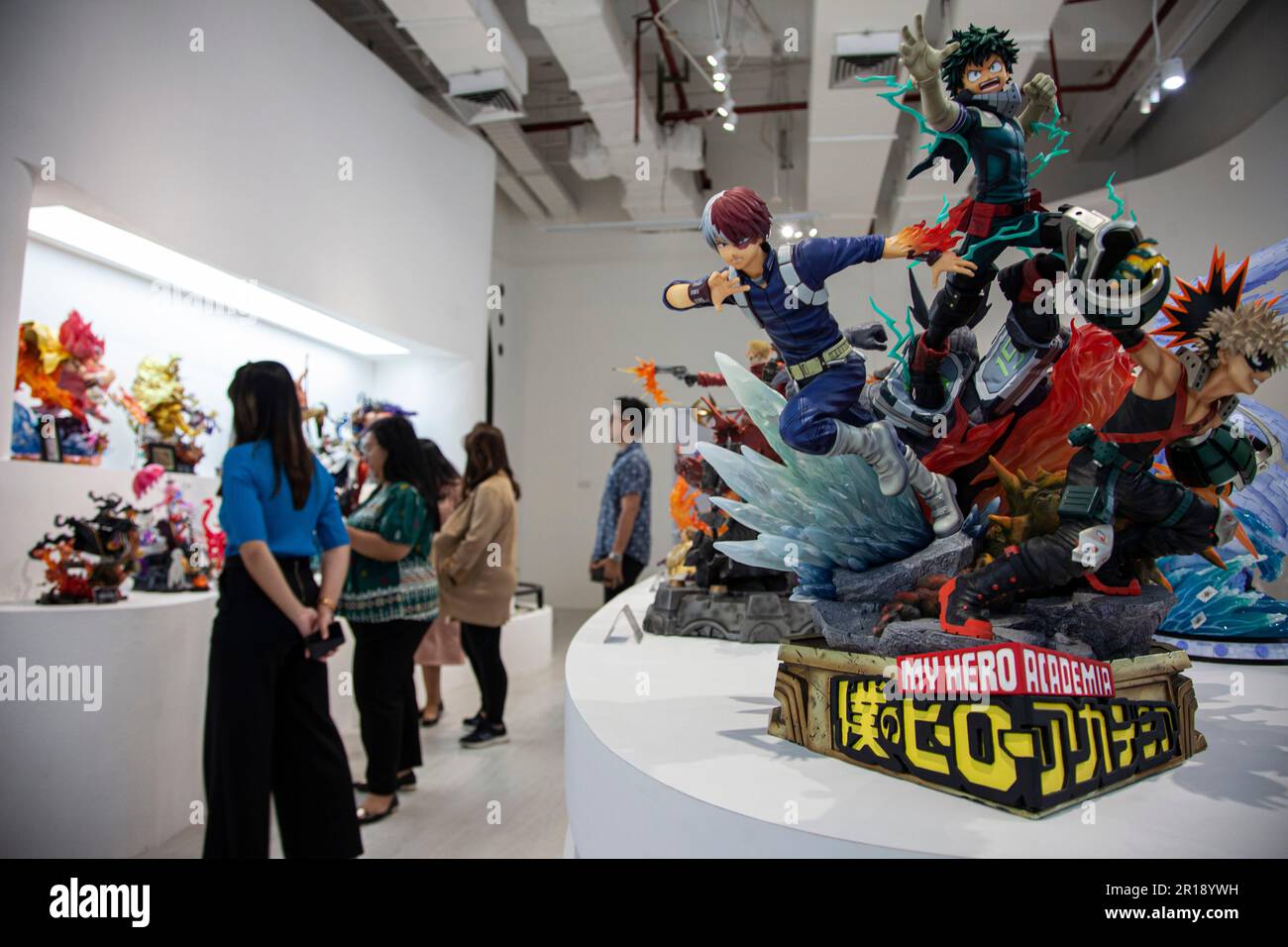 Visitors observe a collection of superhero statues at Statue4Heroes