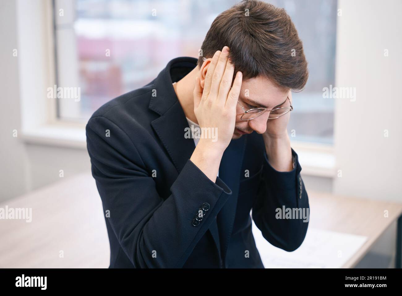 Man is massaging sore temples, feeling headache Stock Photo