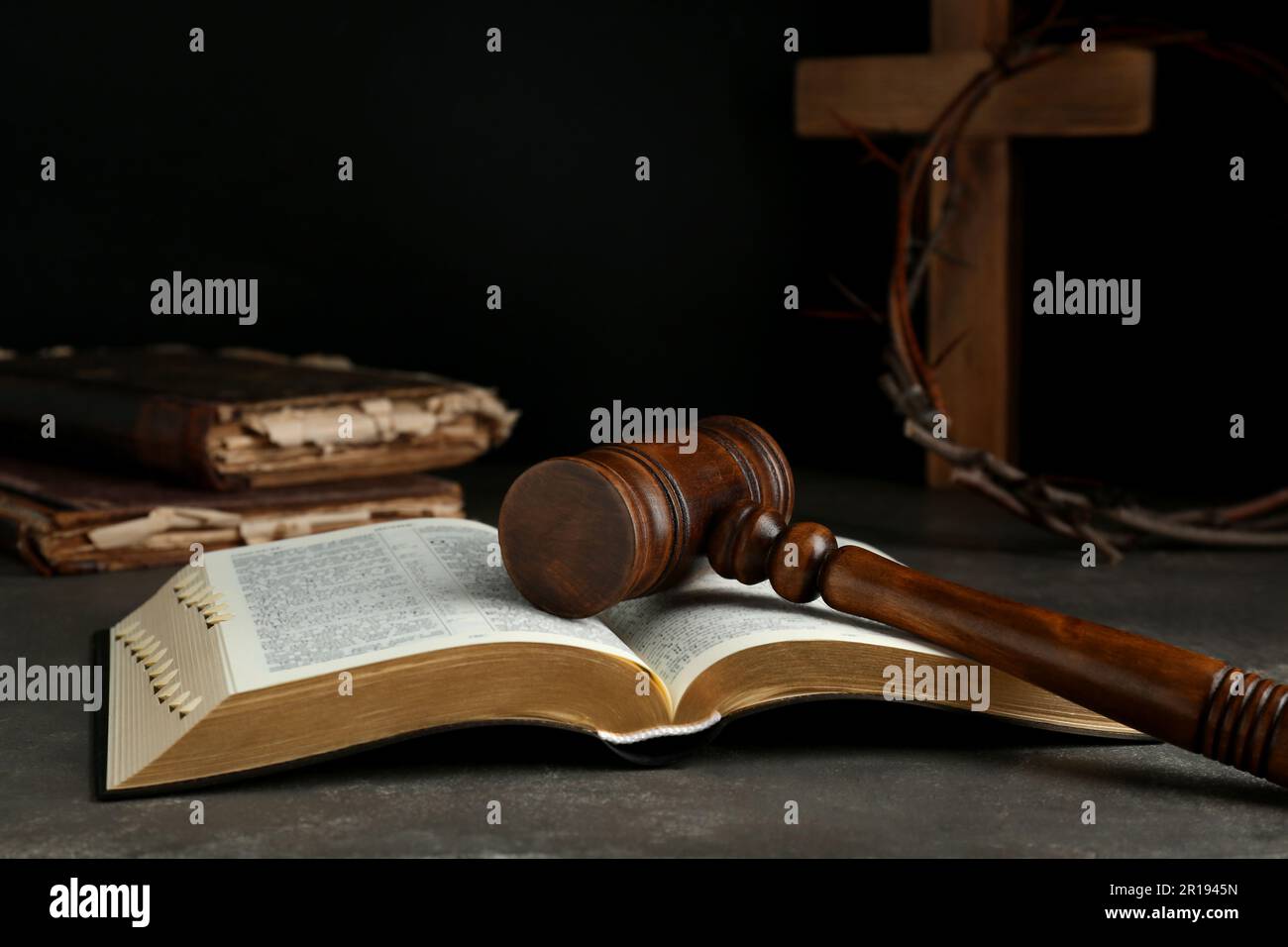 Judge gavel, bible, wooden cross and crown of thorns on grey table