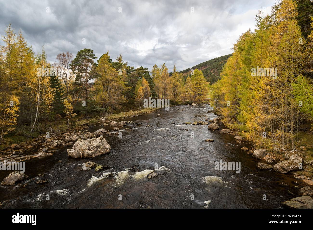 Scottish landscape in the Highlands, a river with trees on either sides ...