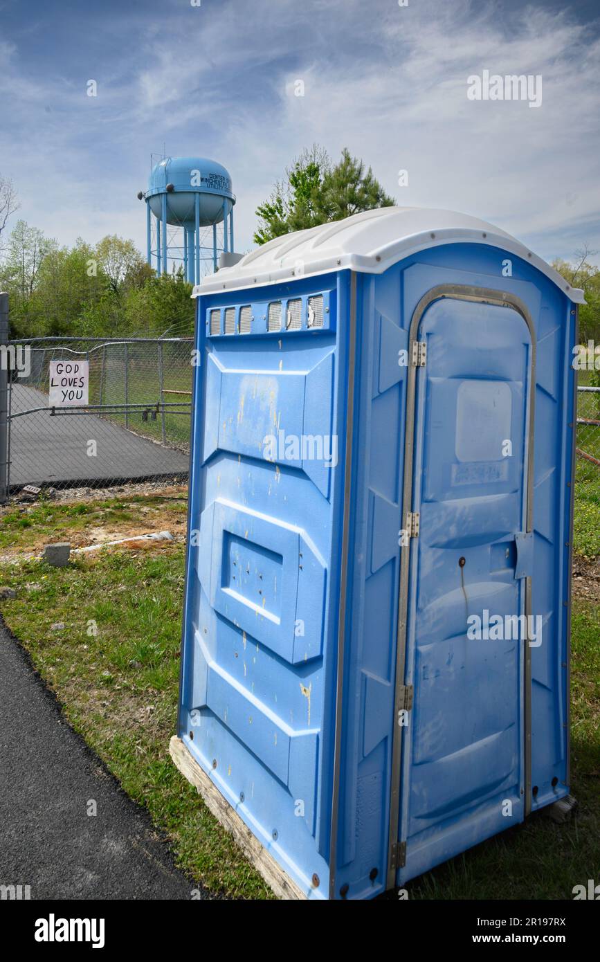 God loves you sign with port-a-potty and water tower Stock Photo