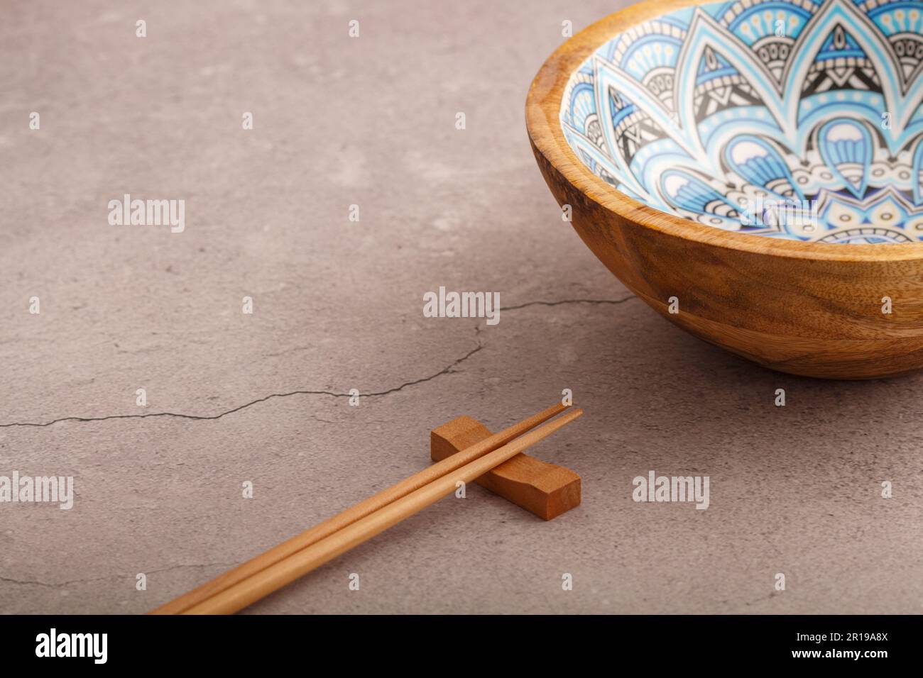 Close up of empty asian style wooden bowl and bamboo chopstick. Copy space Stock Photo