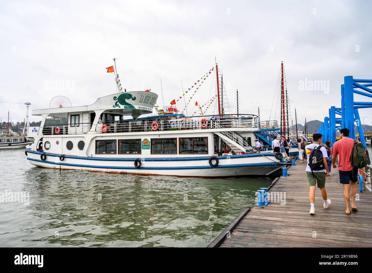Tourists boarding the La Muse Cruise boat for a trip to the Bai Tu Long area of the Halong Bay archipelago, North East Vietnam. Stock Photo