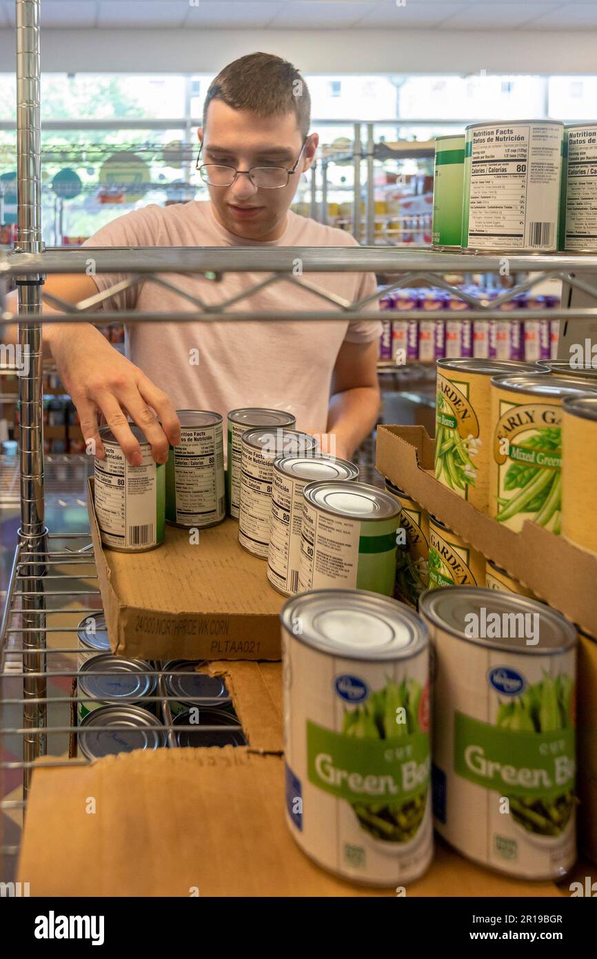 Detroit, Michigan - Student employee Ethan Cassatt stocks the shelves at the Wayne State University food pantry. Although open to anyone, the food pan Stock Photo