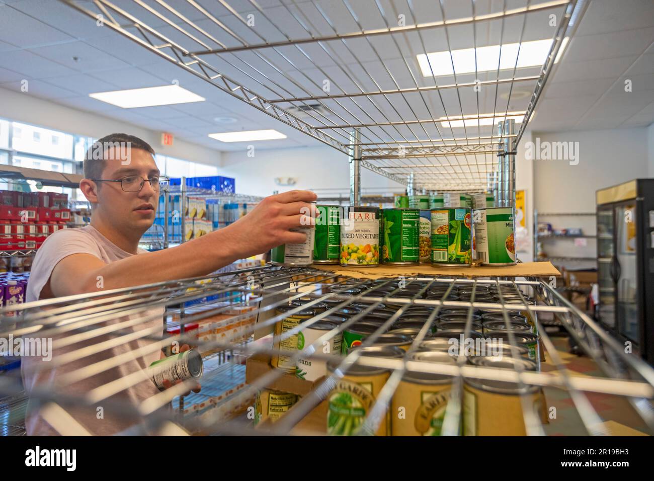 Detroit, Michigan - Student employee Ethan Cassatt stocks the shelves at the Wayne State University food pantry. Although open to anyone, the food pan Stock Photo