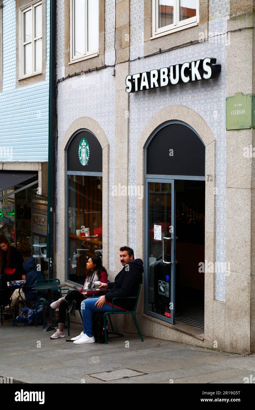 People sitting outside the Starbucks coffee cafe on Praça da Liberdade, Porto / Oporto, Portugal Stock Photo
