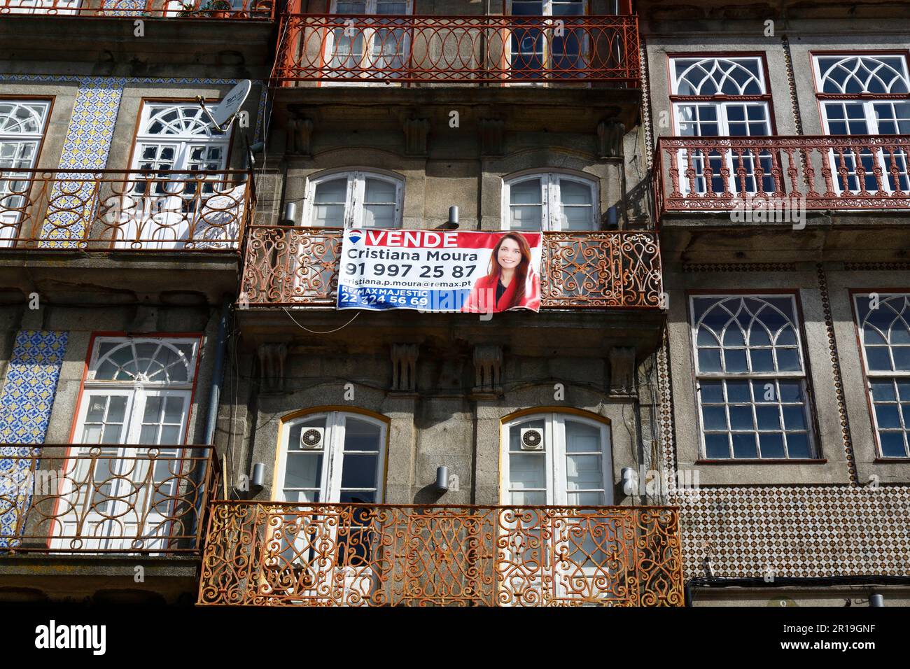 For sale sign on balcony of historic apartment building on the