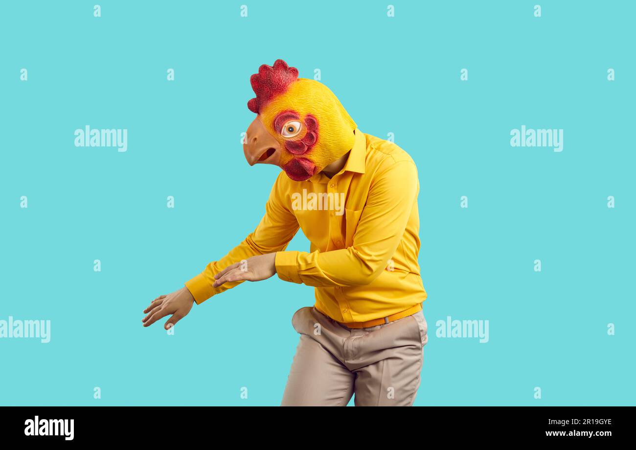 Funny crazy man with chicken head dancing isolated on pastel light blue ...