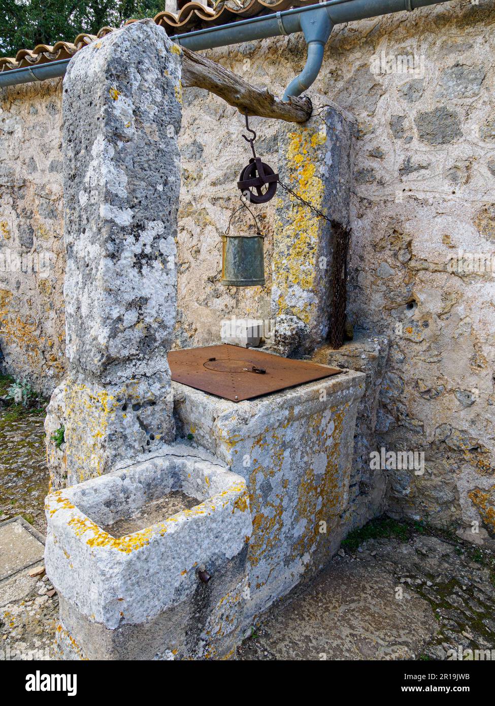 Old well with bucket and trough in the Santuari de la Mare de Deu del Refugi in the Castell d'Alaro Tramuntana Majorca Stock Photo