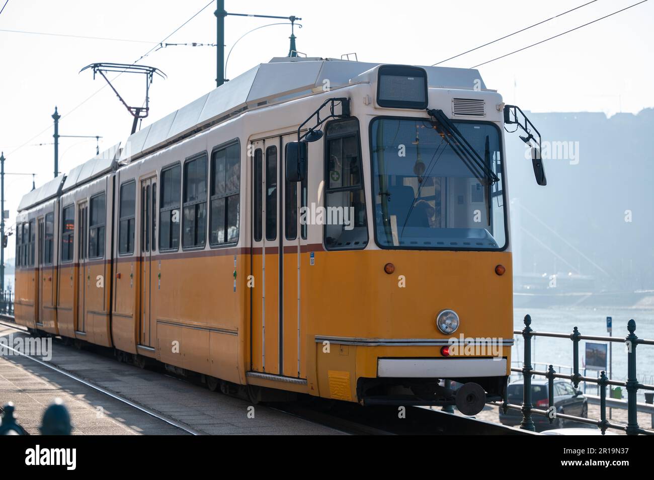 Distinctive yellow and white commuter railway train and carriage in Budapest, Hungary on the banks of the River Danube Stock Photo