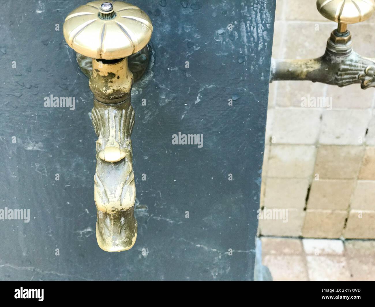 Yellow old vintage forged cast antique faucet, faucet, brass fittings, copper for drinking, washing feet and hands. The background. Stock Photo