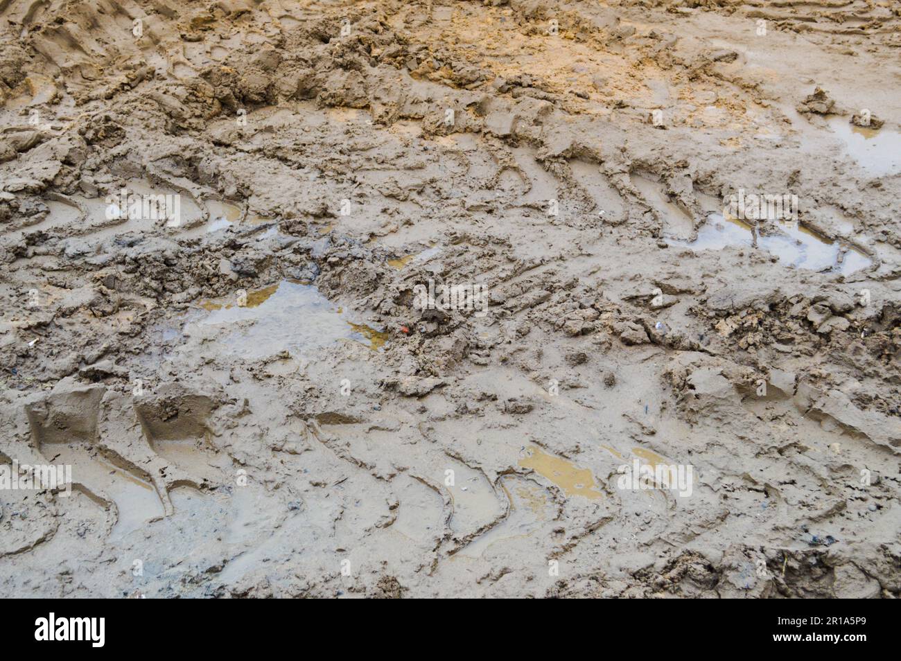Texture of a dirty bad dirt road dirt road with puddles and clay drying