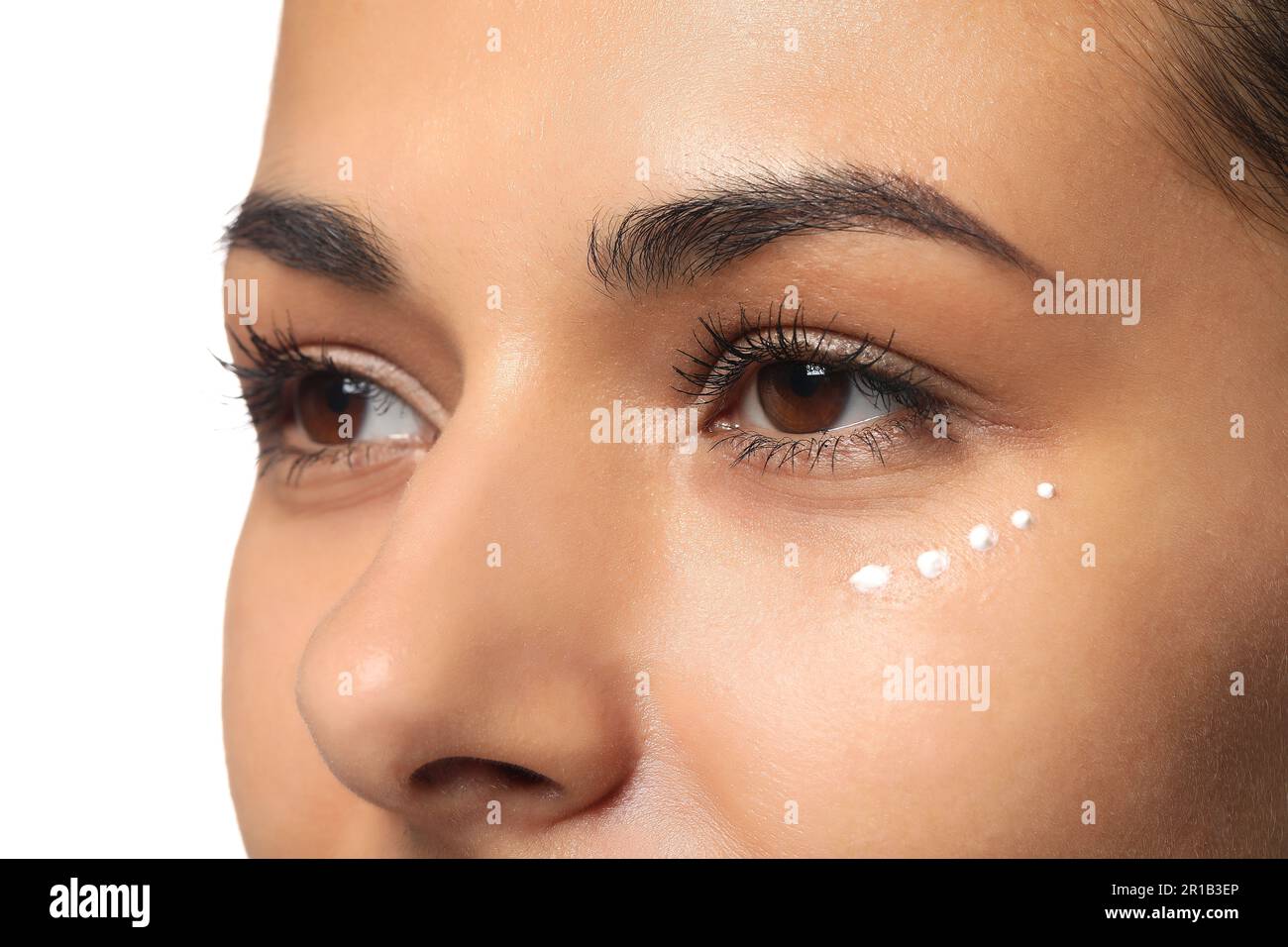 Woman with eye cream on white background, closeup. Skin care Stock Photo