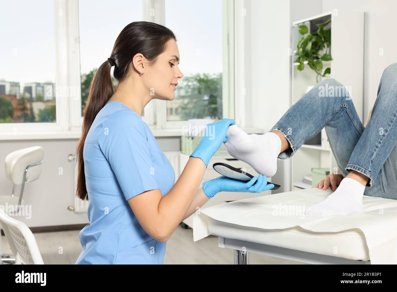 Beautiful female orthopedist fitting insole to patient's foot in hospital Stock Photo Alamy