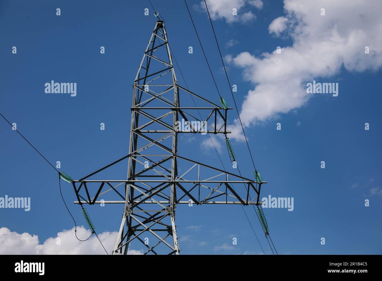 High voltage tower under blue cloudy sky Stock Photo - Alamy