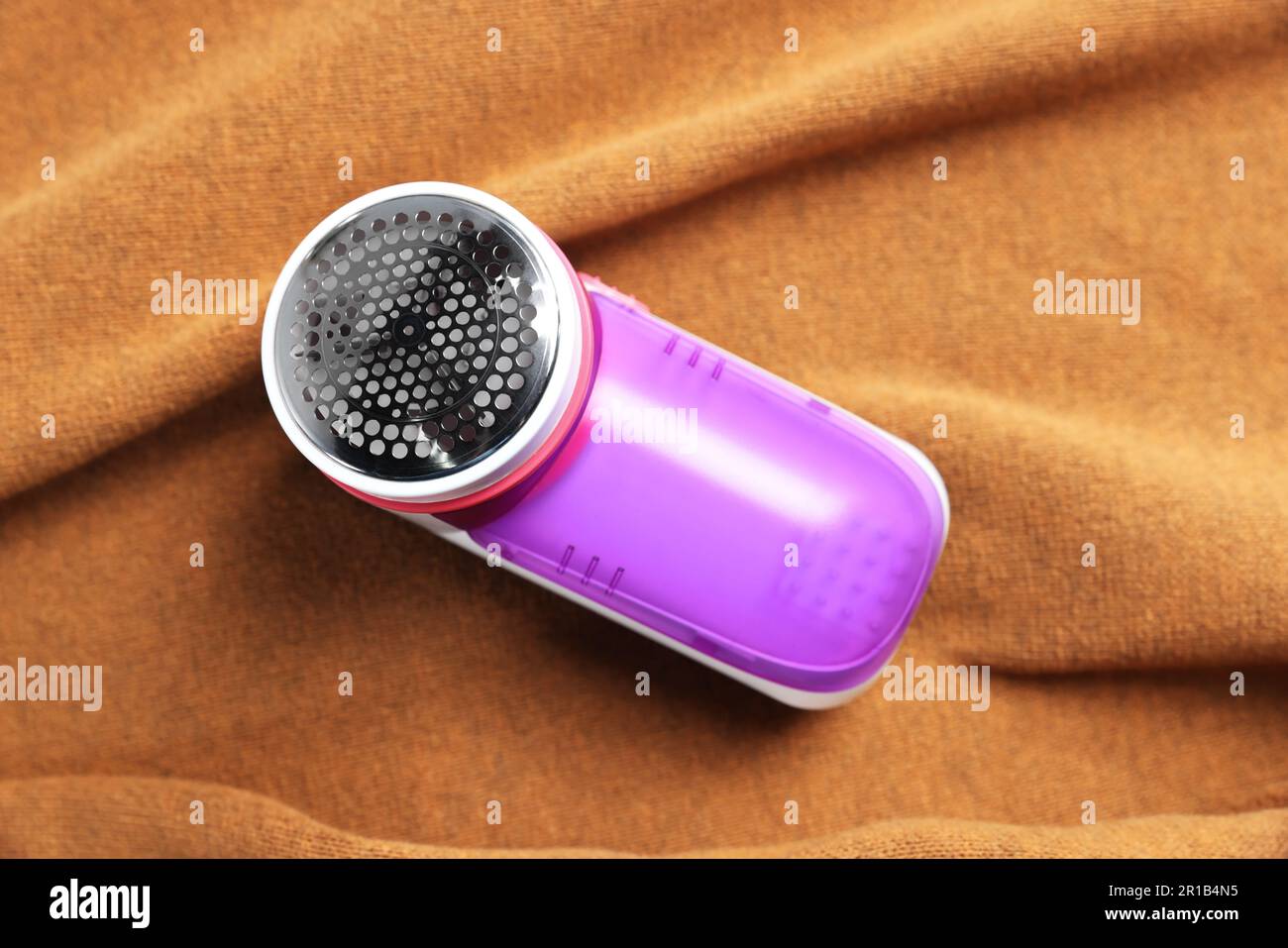 Modern fabric shaver on brown cloth, top view Stock Photo - Alamy
