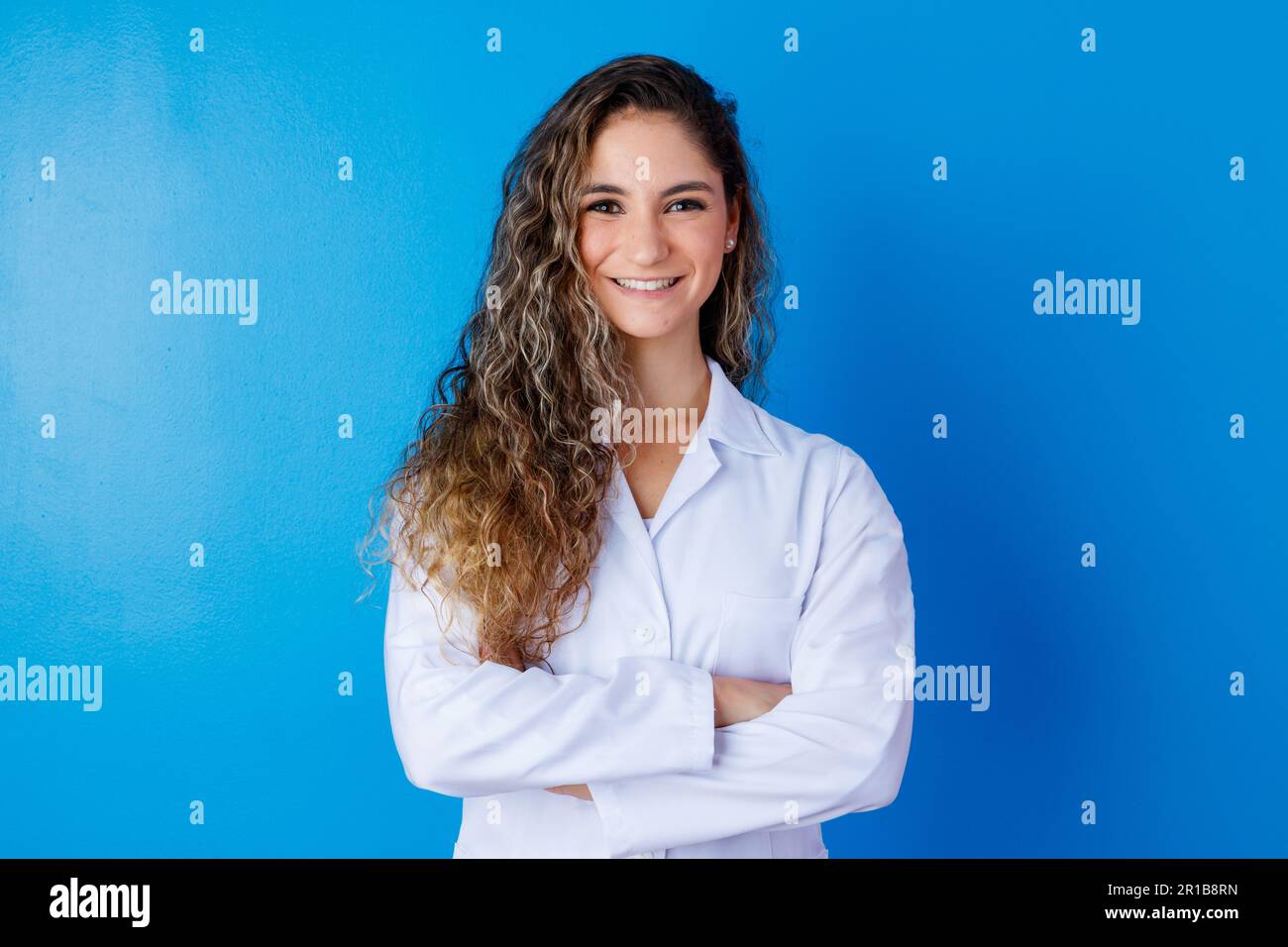 Young girl in lab coat on blue background with space for text. Woman