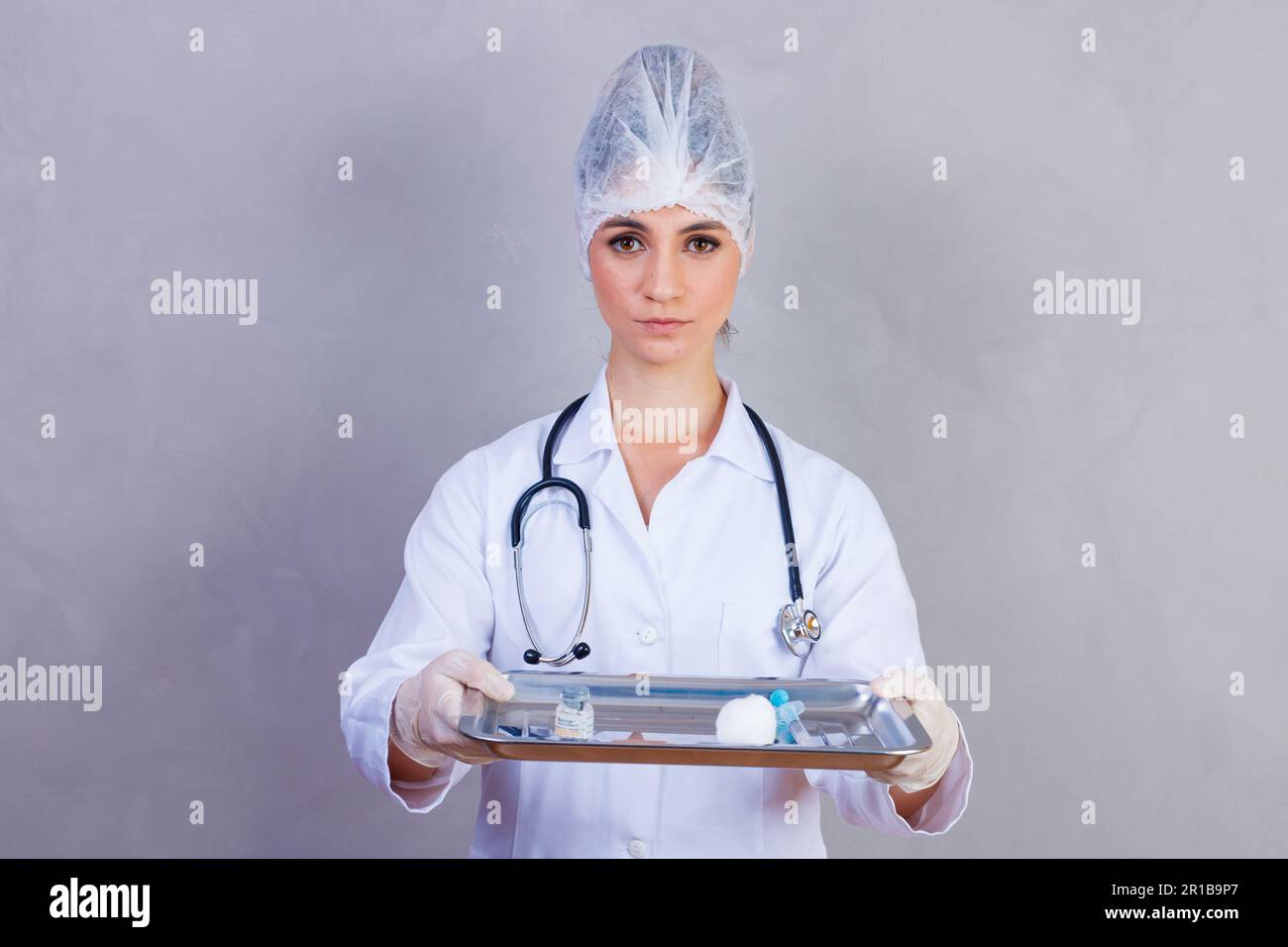 nurse holding tray with medicines on gray background. Doctors on gray