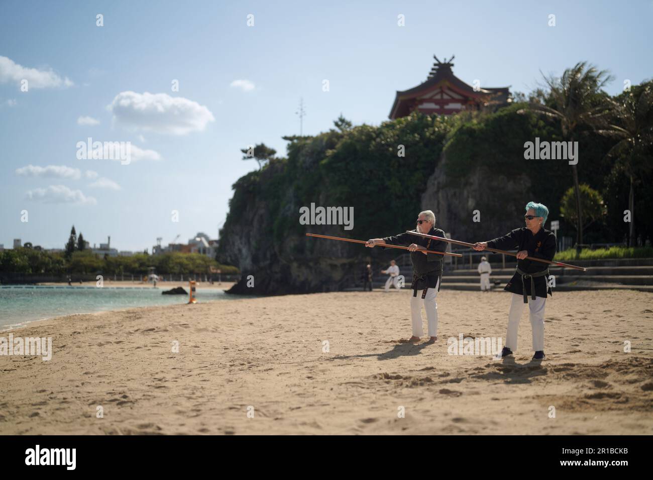 Husband and wife retirees kobudo training on the Naminoue Beach in Naha City, Okinawa. Stock Photo