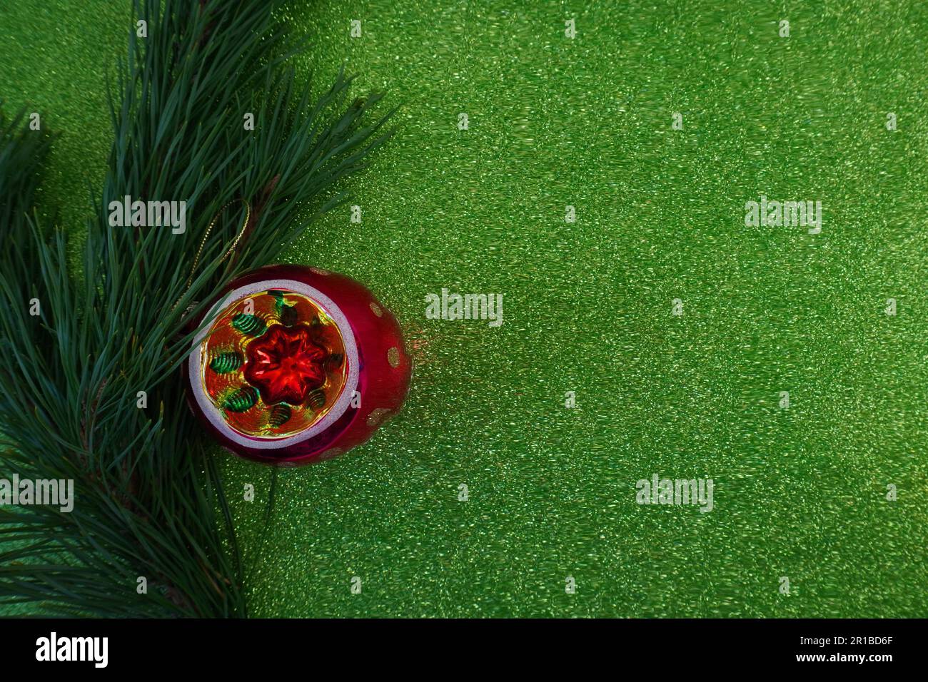 green christmas background with fir tree branch and christmas balls and ...