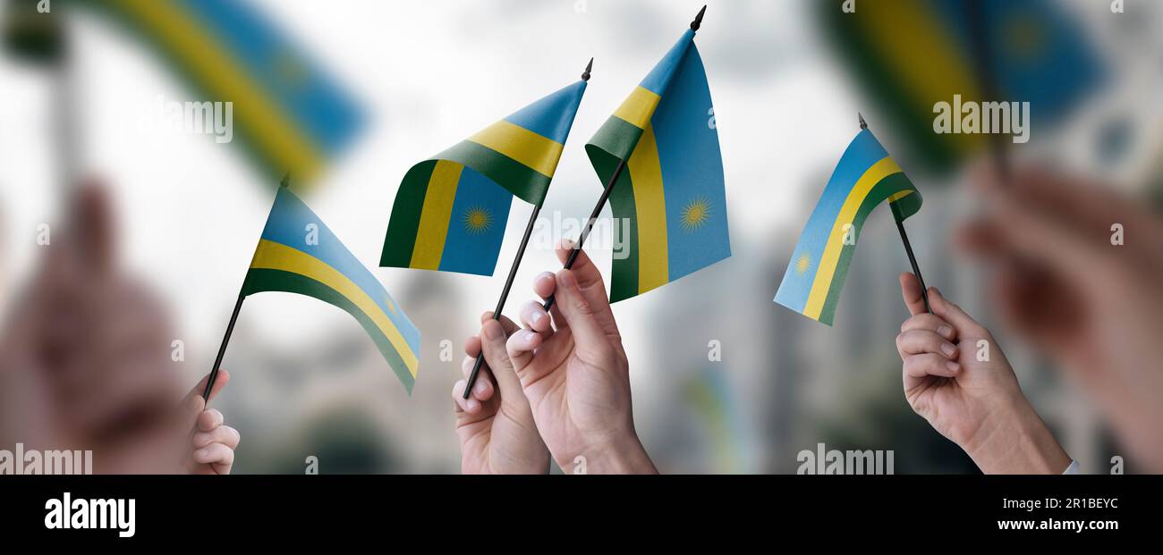 A group of people holding small flags of the Rwanda in their hands ...