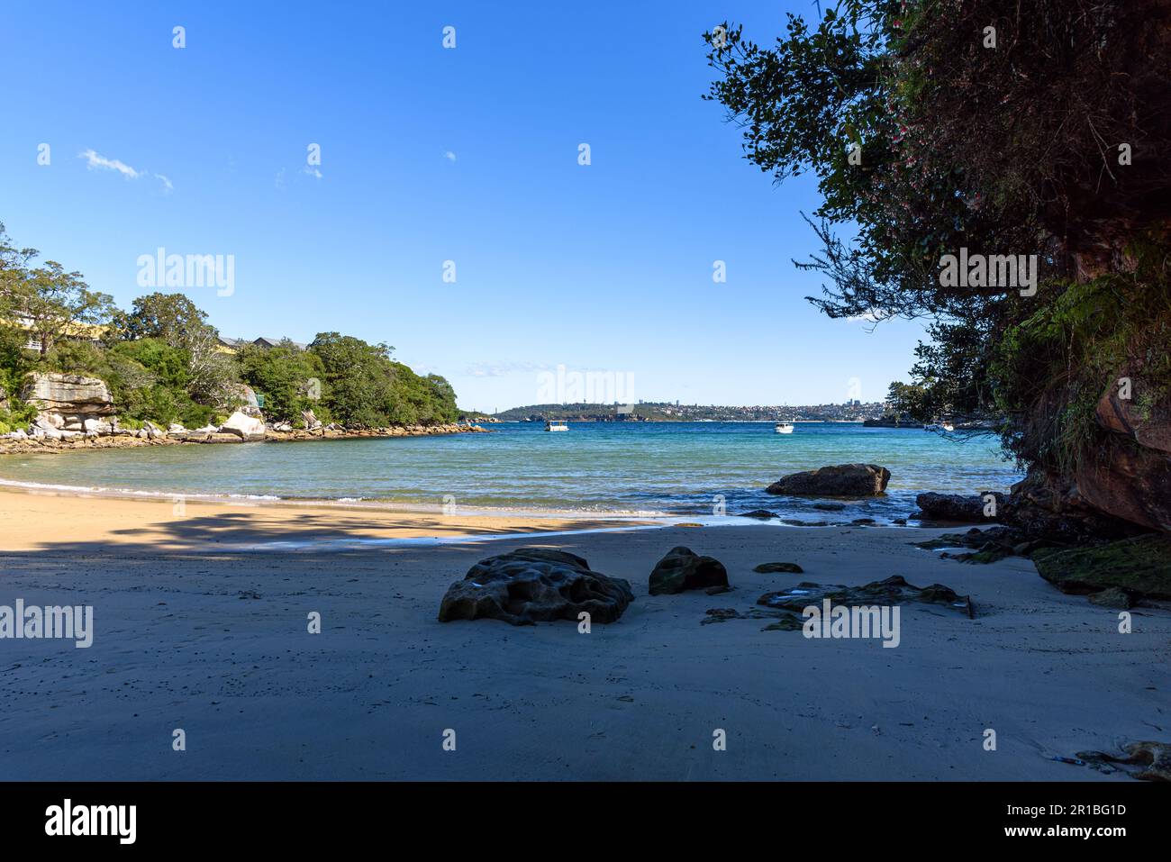 Rocks on the sand of Collins Beach in Manly, Sydney, looking out into the North Harbour Stock Photo