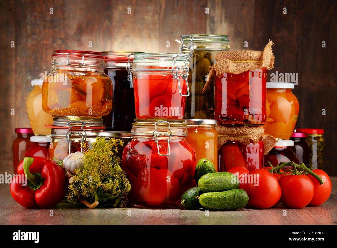 Jars with pickled vegetables and fruity compotes. Preserved food Stock Photo