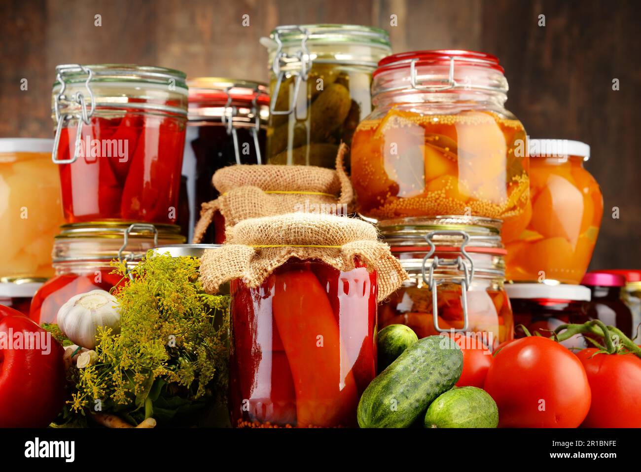 Jars with pickled vegetables and fruity compotes. Preserved food Stock Photo