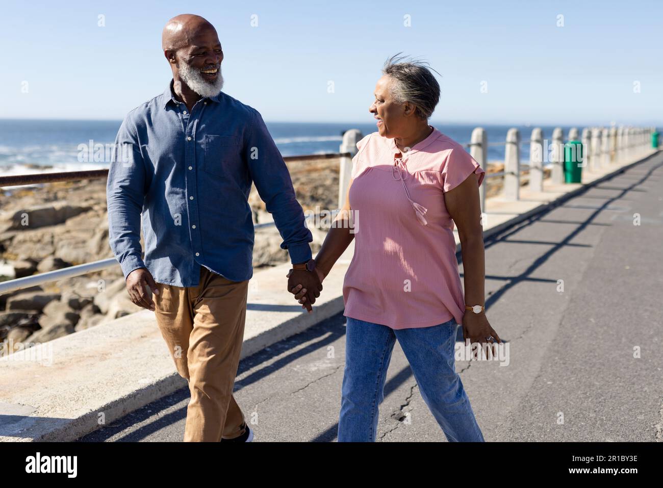 Happy senior african american couple walking on promenade at seaside ...