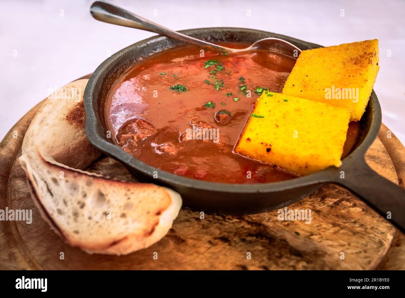Gulyas, traditional Hungarian dish, hearty stew made with beef or pork, onions, paprika, tomatoes, and various spices. Summer tavern in Slovenia. Stock Photo