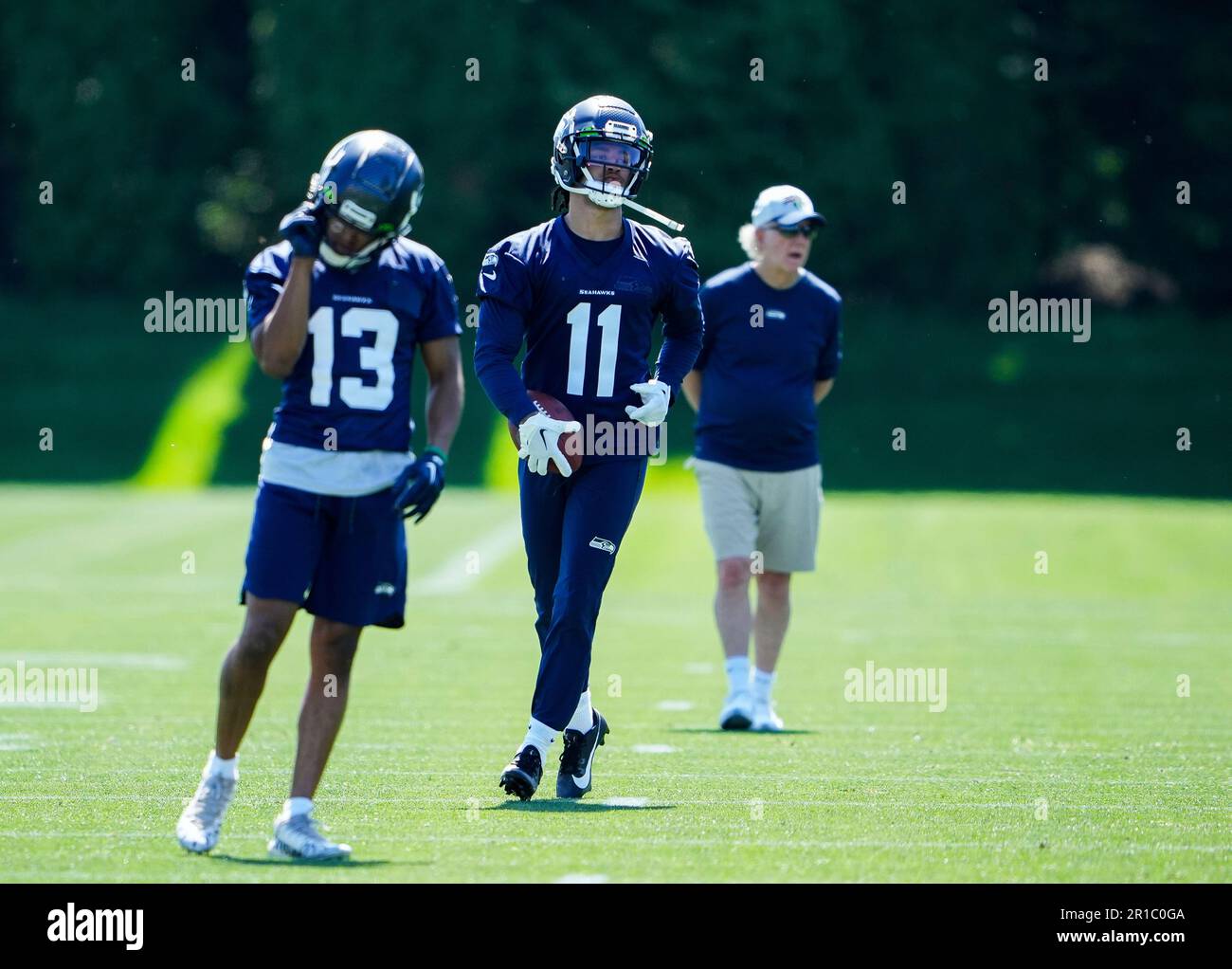 Seattle Seahawks wide receiver Jaxon Smith-Njigba (11) runs with the  football as wide receiver JuanCarlos Santana (13) stands by during the NFL  football team's rookie minicamp, Friday, May 12, 2023, in Renton,