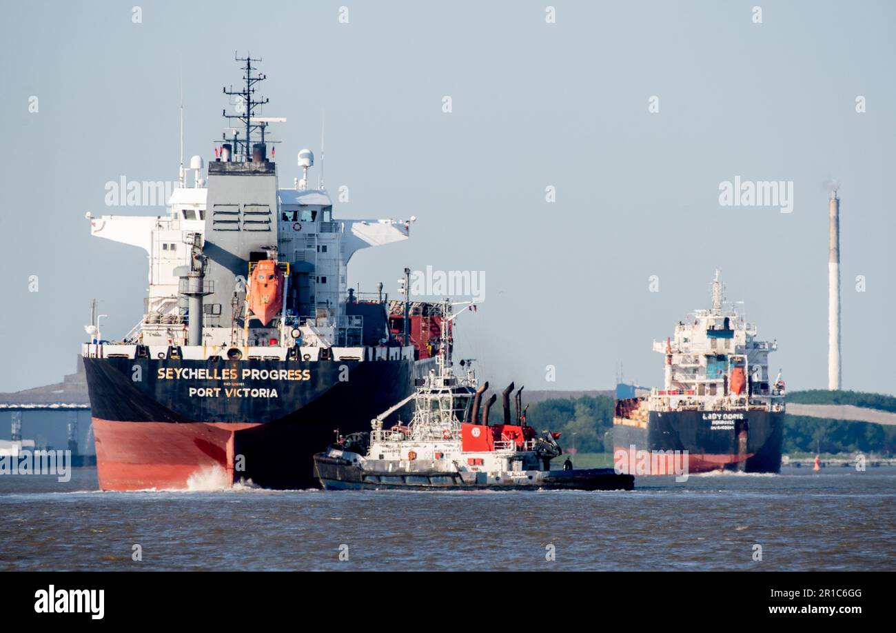 Nordenham, Germany. 12th May, 2023. Two cargo ships and a tugboat are underway on the Weser in sunny weather. Credit: Hauke-Christian Dittrich/dpa/Alamy Live News Stock Photo