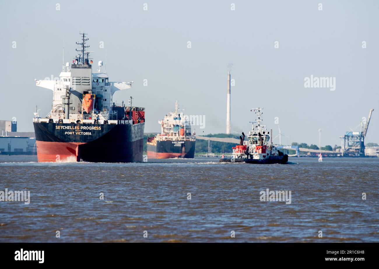 Nordenham, Germany. 12th May, 2023. Two cargo ships and a tugboat are underway on the Weser in sunny weather. Credit: Hauke-Christian Dittrich/dpa/Alamy Live News Stock Photo