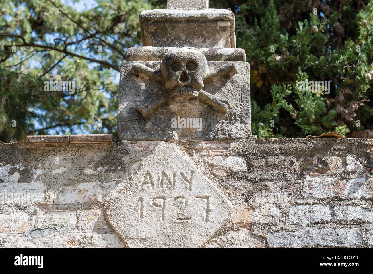 carved skull and cross in the cemetery main entrance, Merola, Catalonia, Spain Stock Photo