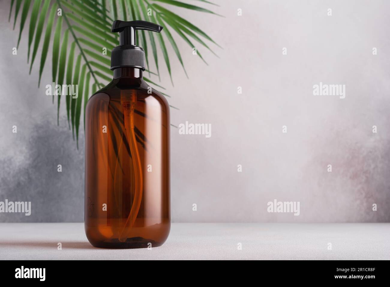 Recycled plastic pump bottle for mockup with palm leaves. Spa and