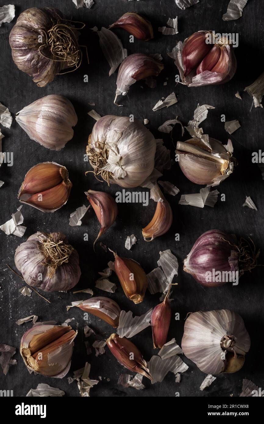 Fresh garlic bulbs and cloves grouped on black background. Flat lay ...