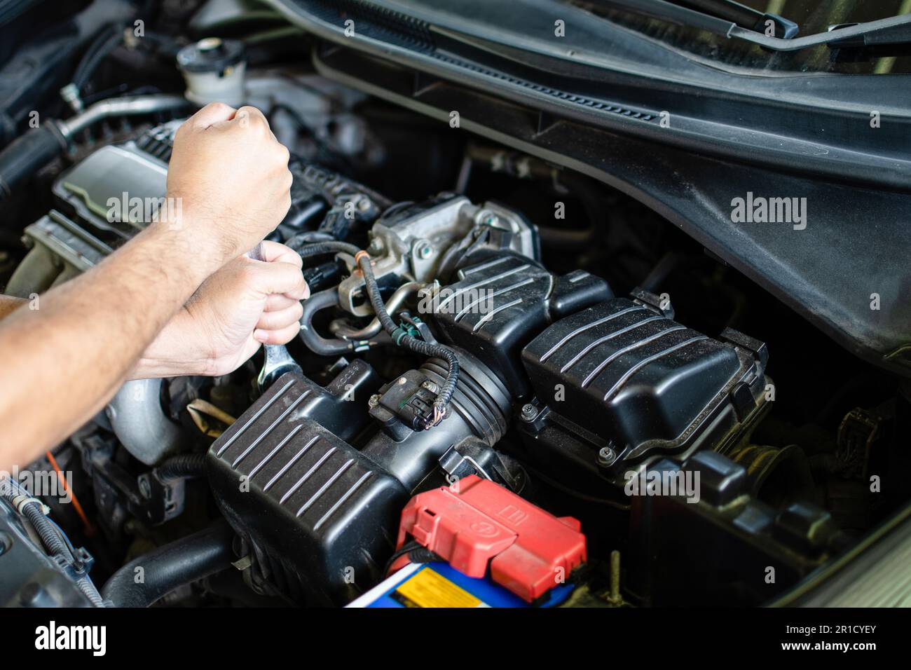 Concept of engine maintenance. Mechanics hold wrench to tighten bolts