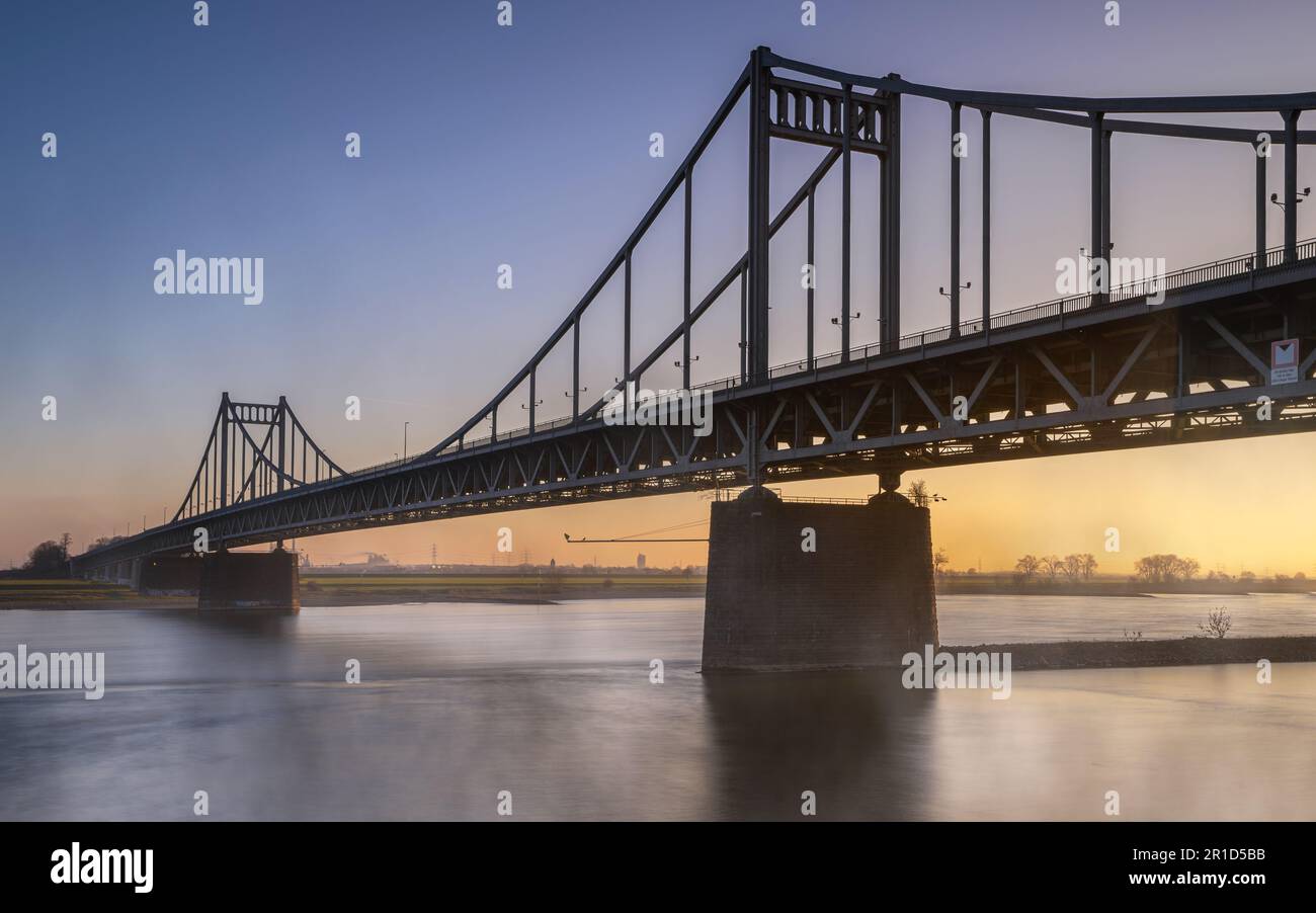 Old bridge crossing the Rhine river during sunset, Krefeld, North Rhine Westphalia, Germany Stock Photo